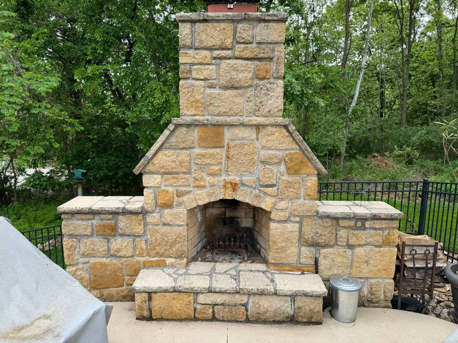 Custom outdoor stone fireplace with an arched firebox